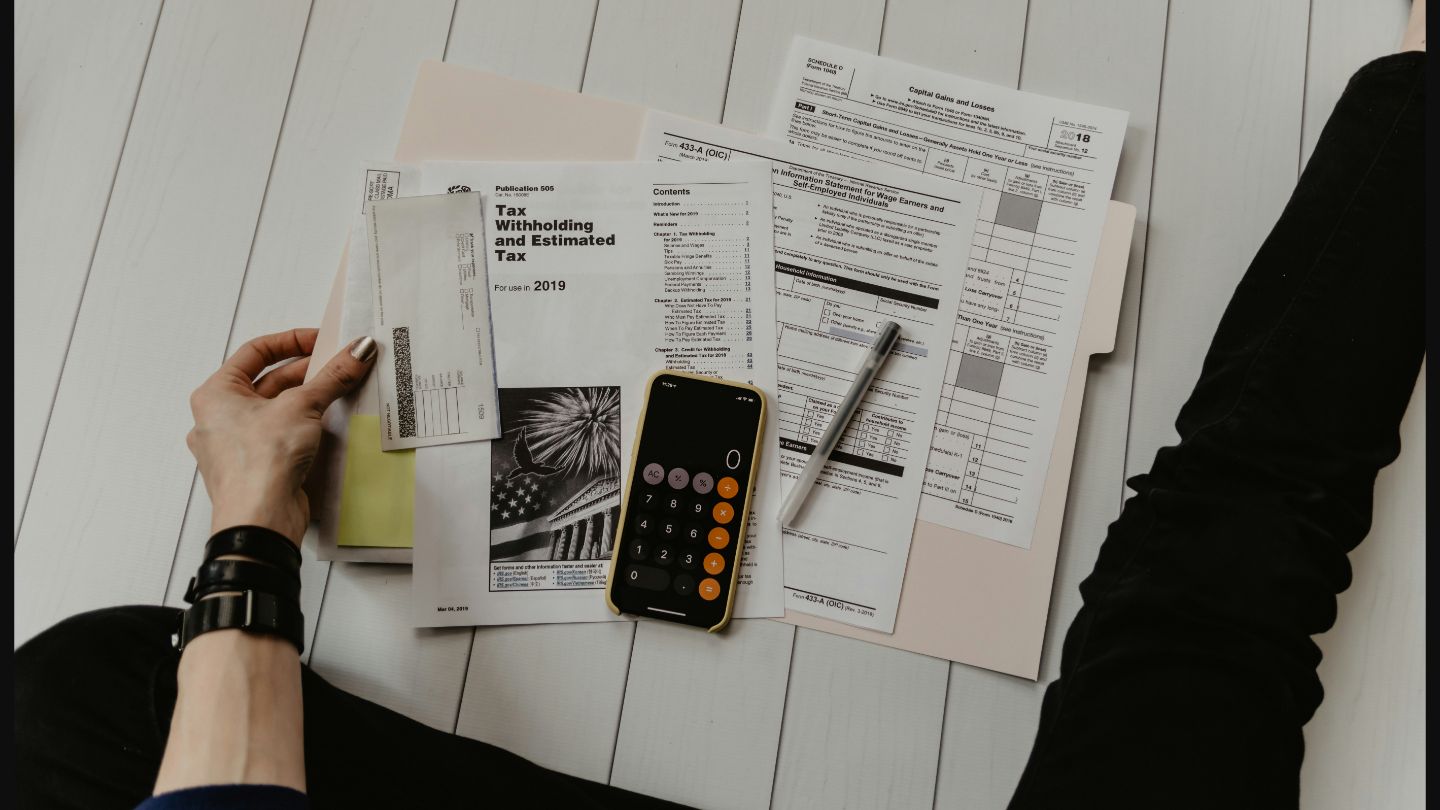 Professional tax preparation workspace with documents, calculator, and financial charts - Credence Global tax consulting services